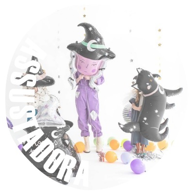 Balões decorativos de festa com figuras de bruxa e golfinho preto com estrelas brancas e balões coloridos no chão.