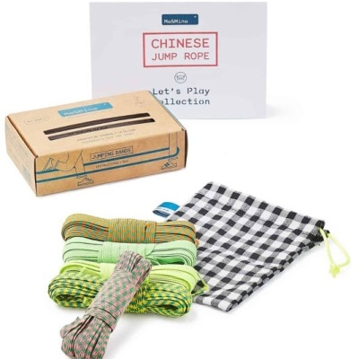 Cordas para saltar coloridas e saco de tecido em preto e branco junto à embalagem de cartão