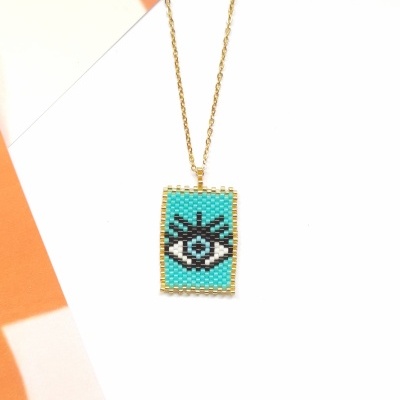 Colar dourado com pendente retangular colorido com padrão de olho