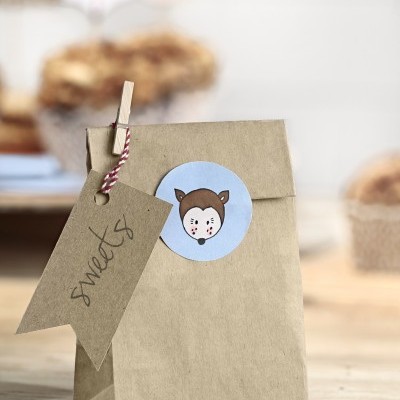 Saco de papel castanho com autocolante de animal e etiqueta com a palavra 'sweets'