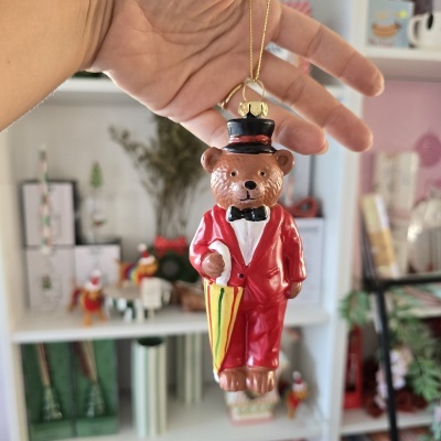 Enfeite pendente em forma de urso vestido com fato vermelho e chapéu preto