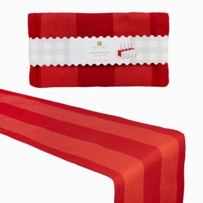 Caminho de mesa vermelho com faixas e etiqueta com informações.