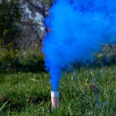 Fumo azul a sair de cilindro branco na relva