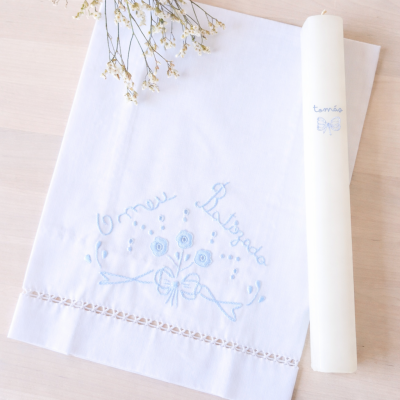 Toalha branca bordada e vela branca com escrita azul