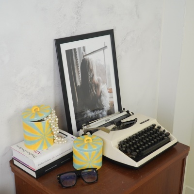 Secretária com máquina de escrever branca e objetos decorativos