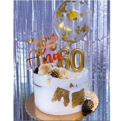 Bolo branco com decoração dourada, números 60 dourados e balão com confetes dourados