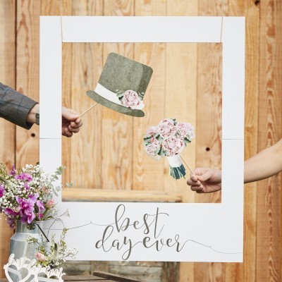Moldura branca para fotografia com texto 'best day ever' e adereços de chapéu verde e bouquet de flores cor de rosa