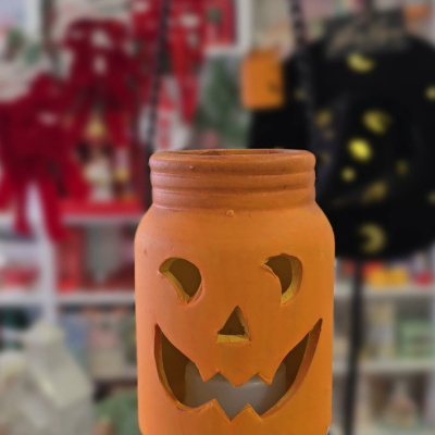 Lanterna de Halloween em cerâmica laranja com rosto recortado e corrente preta