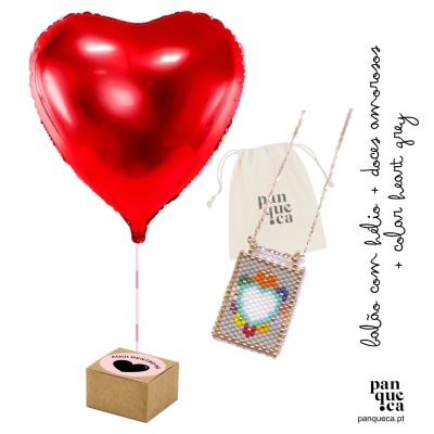 Balão metálico vermelho em forma de coração ao lado de caixa castanha e saco branco com colar colorido