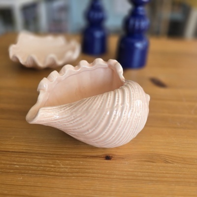 Peças decorativas em cerâmica em forma de concha sobre mesa de madeira