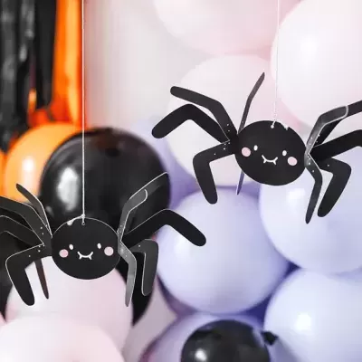 Duas aranhas decorativas pretas suspensas com balões coloridos ao fundo