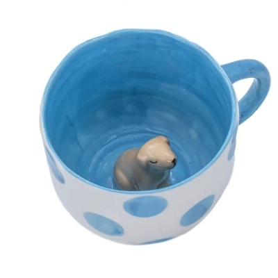 Caneca cerâmica azul com bolinhas e foca pequena no fundo