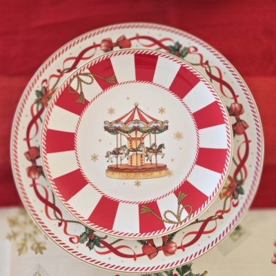 Pratos decorativos de Natal com padrão de carrossel e fita vermelha.