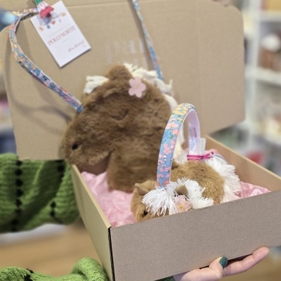 Caixa com bolsas de peluche castanhas com alças floridas azuis