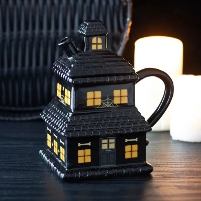 Caneca preta de cerâmica em forma de casa com janelas amarelas e decoração de Halloween