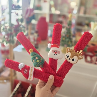 Elásticos vermelhos decorados com motivos natalícios em feltro de rosto de Pai Natal, rena, árvore de Natal e etiqueta com o texto Christmas.