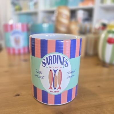 Lata de sardinhas com riscas cor de salmão e azul e texto em inglês.