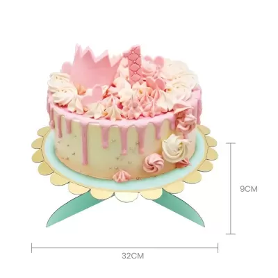 Bolo decorado com creme branco e rosa, cobertura rosa, detalhes em chantilly, coroa e peça de waffle rosa, sobre base azul clara com suporte verde.