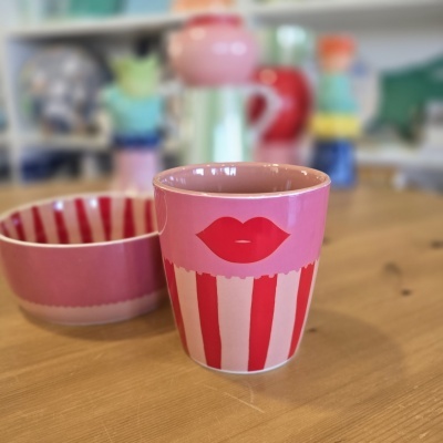 Copo e taça de cerâmica rosa e vermelho com padrão de riscas e lábios desenhados