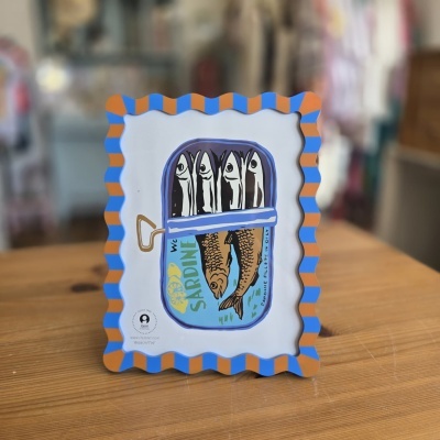 Moldura colorida com riscas azul e castanho e imagem de uma lata de sardinhas.