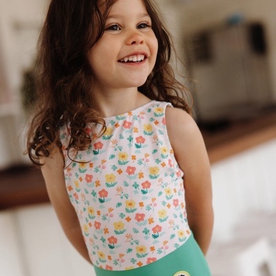 Menina com fato de banho verde e branco com padrão de flores