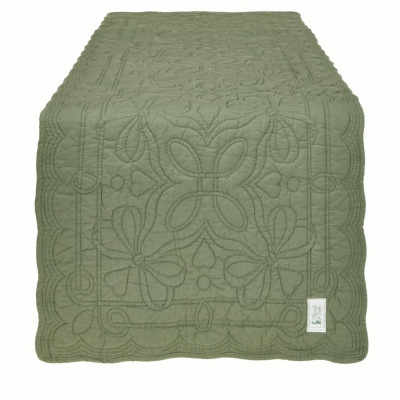 Colcha verde com padrão de quilting floral e etiqueta branca