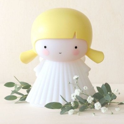 Figura decorativa com cabeça amarela e corpo branco em superfície clara com flores