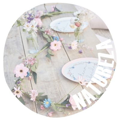 Mesa de madeira com pratos decorativos florais e arranjo de flores artificiais coloridas