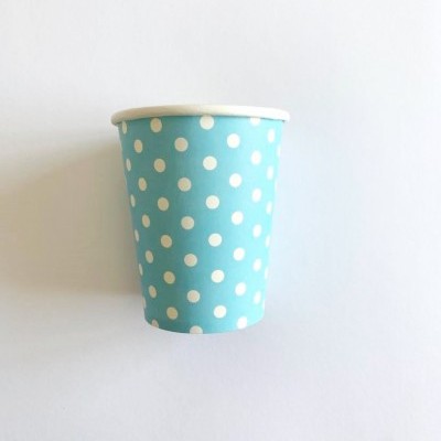 Copo de papel azul com bolinhas brancas sobre fundo branco