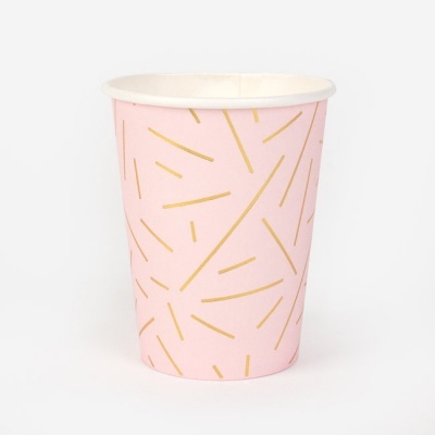 Copo descartável cor-de-rosa com riscas amarelas em fundo branco