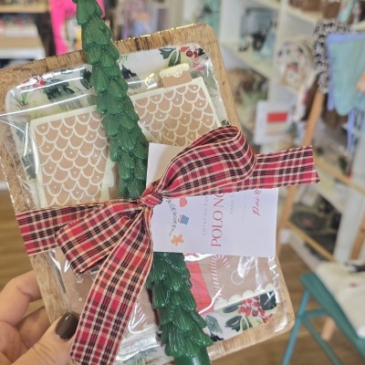 Presente com prato de madeira, vela verde em forma de árvore, e laço xadrez