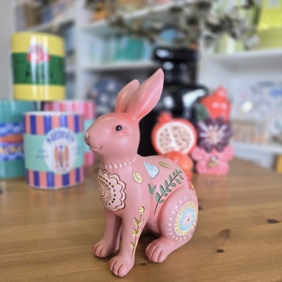 Estatueta decorativa de coelho rosa com padrões florais