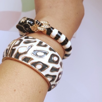 Pulseiras com padrões em branco, preto e dourado num pulso