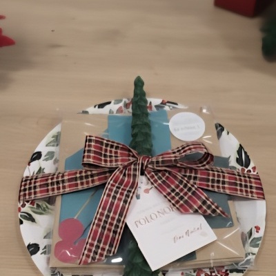 Conjunto para presente em prato com padrão de folhas, vela verde e fita xadrez