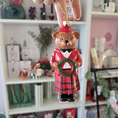Enfeite de Natal de urso vermelho a segurar uma coroa verde