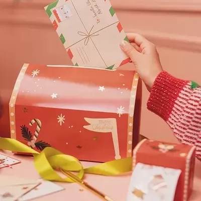 Correio de Natal vermelho decorado e mão a segurar carta com tema Natal