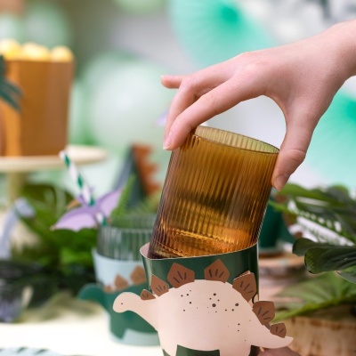 Porta-copo de papel com dinossauro e copo de vidro âmbar com riscas