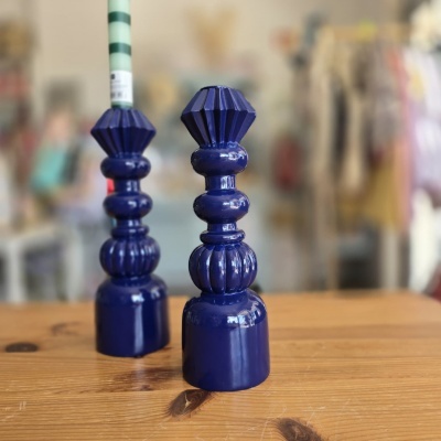 Dois castiçais azuis de cerâmica sobre uma mesa de madeira.