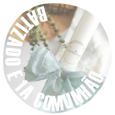 Velas brancas decoradas com laço azul claro em fundo com folhagem