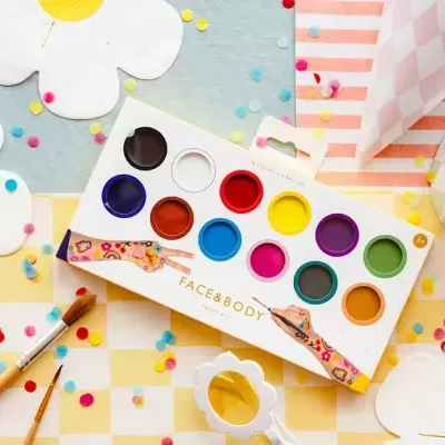 Paleta de tintas coloridas FACE&BODY com pincéis sobre fundo decorado