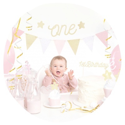 Bebé a celebrar o primeiro aniversário com decoração rosa, branco e dourado