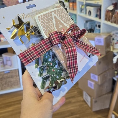 Conjunto de cortadores de bolachas metálicos decorativos para Natal com fita vermelha às riscas.