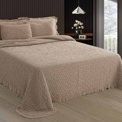 Conjunto de cama bege matelassado com padrão de folhas, em quarto moderno com chão de madeira e parede escura