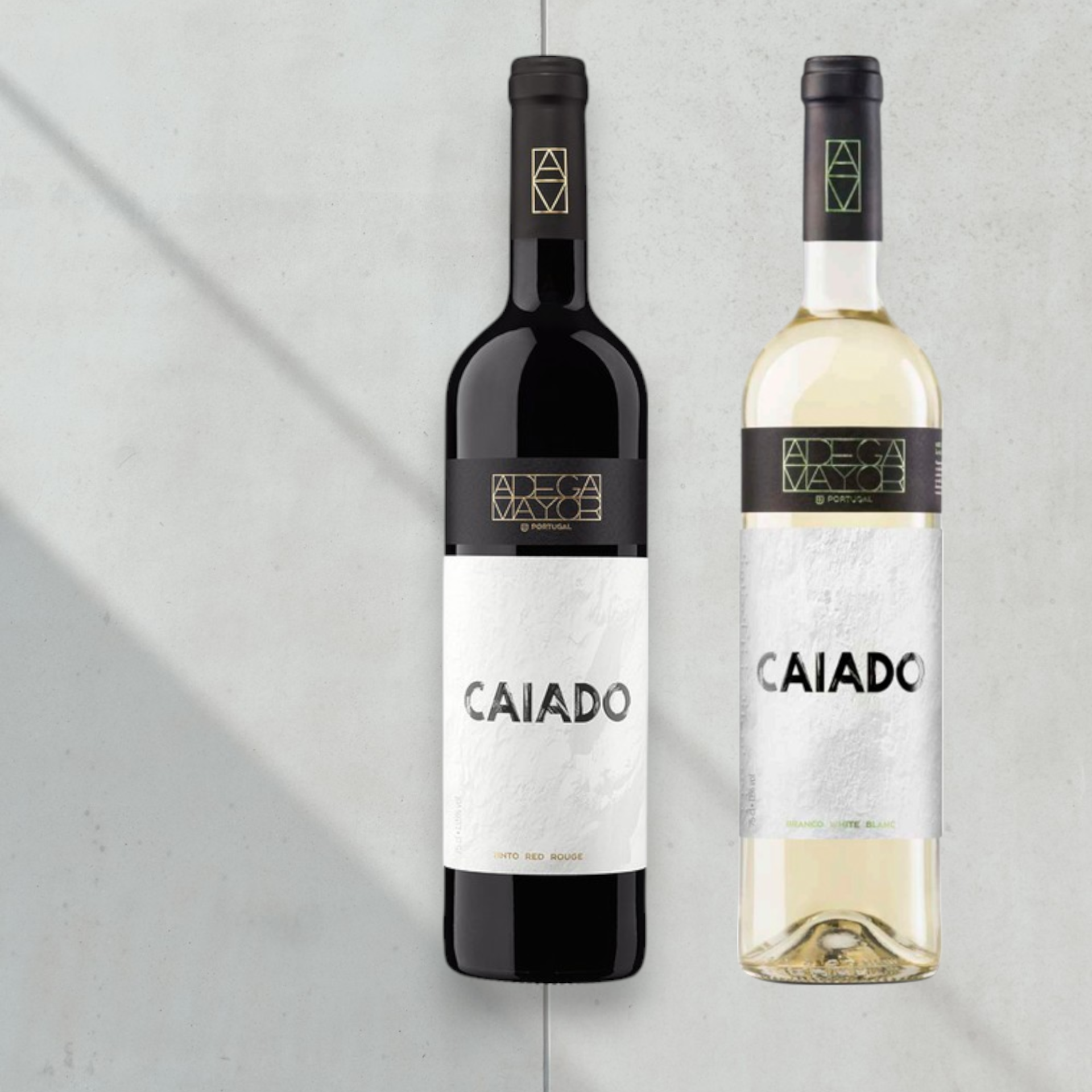 VINHO CAIADO Duas garrafas de vinho, tinto e branco, com rótulos CAIADO em fundo cinzento claro