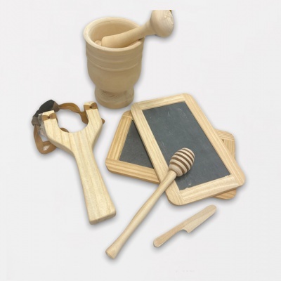 Utensílios de cozinha em madeira clara com almofariz, tabuleiros, colher de mel, faca e espingarda sobre fundo branco