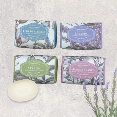 Quatro sabonetes embalados com etiquetas florais e raminhos de lavanda ao lado