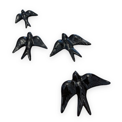 Quatro pássaros decorativos pretos brilhantes dispostos sobre fundo branco