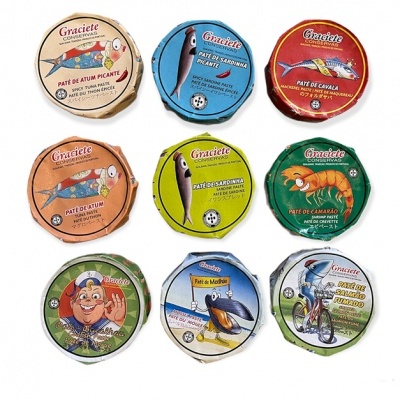 Nove latas redondas coloridas de paté Graciete com ilustrações de peixes e personagens