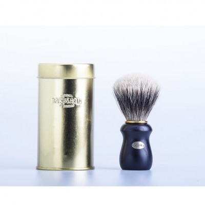 Escova de barbear preta com cerdas cinza ao lado de estojo metálico dourado