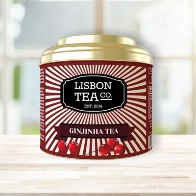 Lata de chá Ginjinha da Lisbon Tea Co. vermelha com tampa dourada e padrão de raios brancos